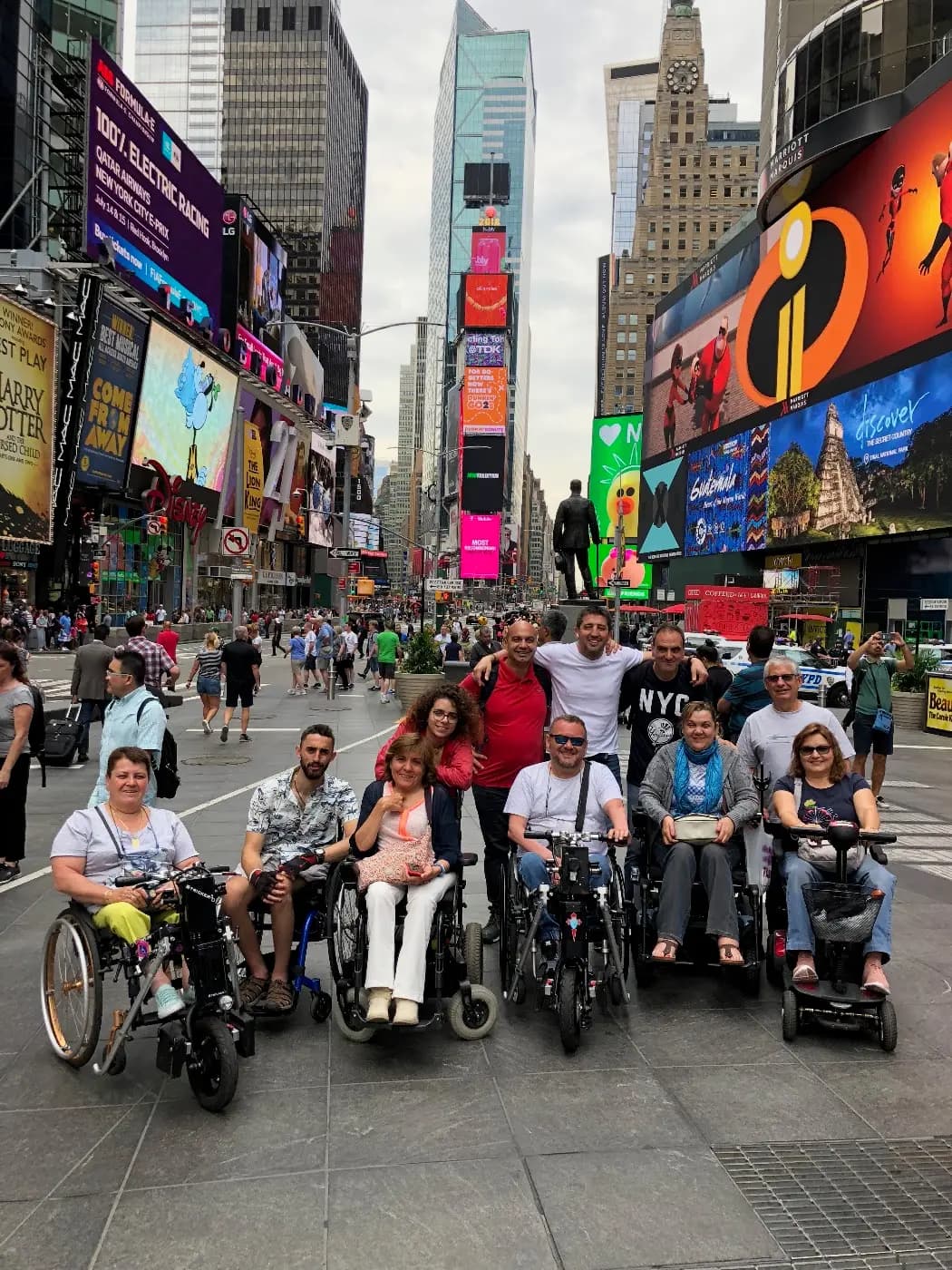 Un grupo de viajeros, varios en silla de ruedas y en scooter, en Times Square, en Nueva York.